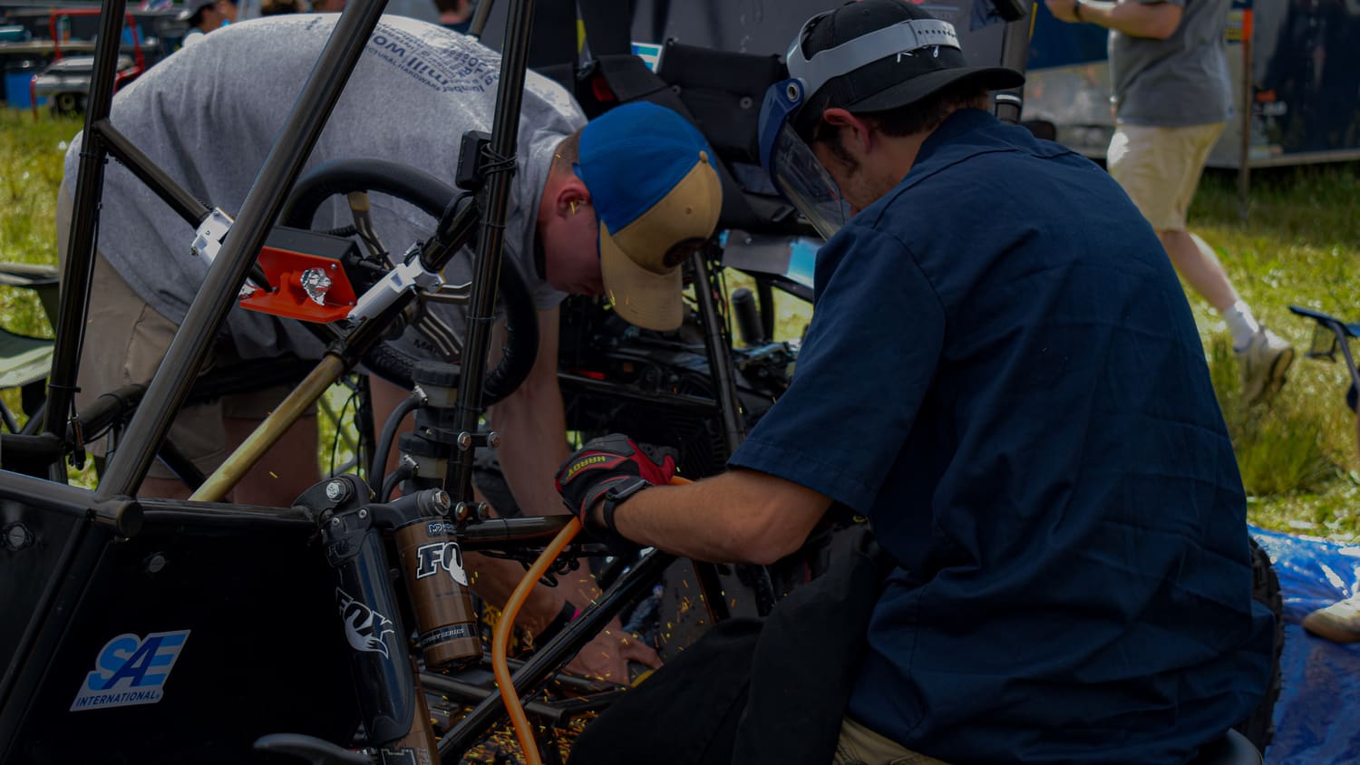 Team members working on GBR4's engine under the tent