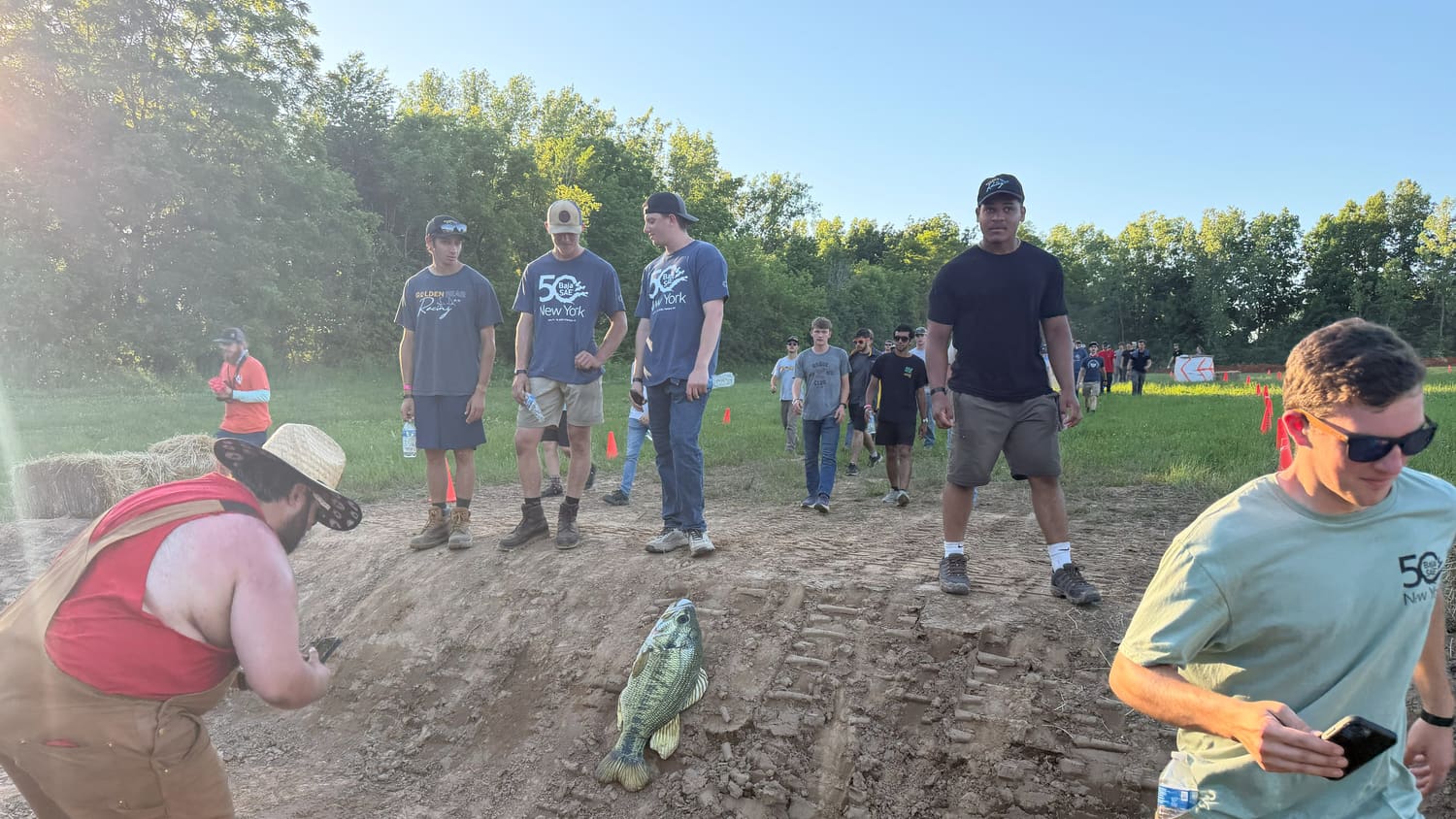 Teams walking the course past a rubber fish someone planted in the dirt