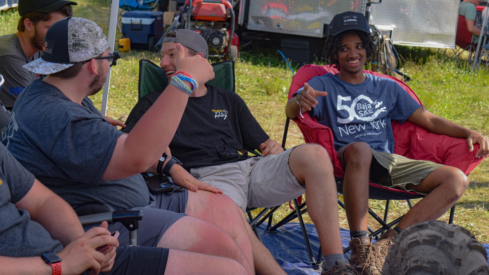 Team members sitting together in camp chairs between competition runs